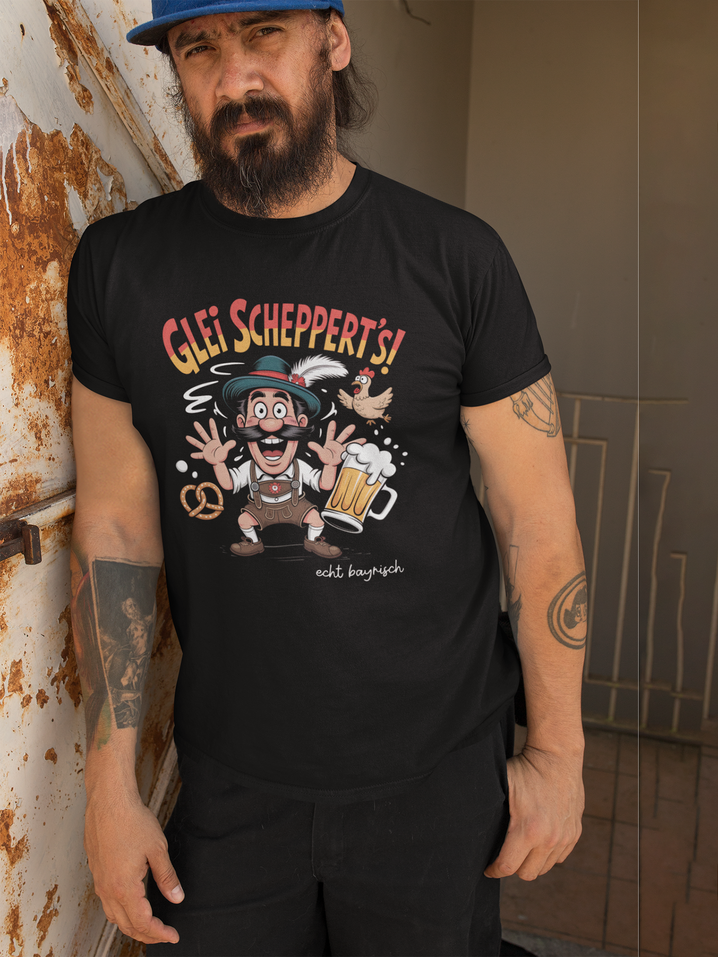 Junger Mann trägt schwarzes T-Shirt mit Fun-Motiv „Glei scheppert’s“, Oberkörperansicht