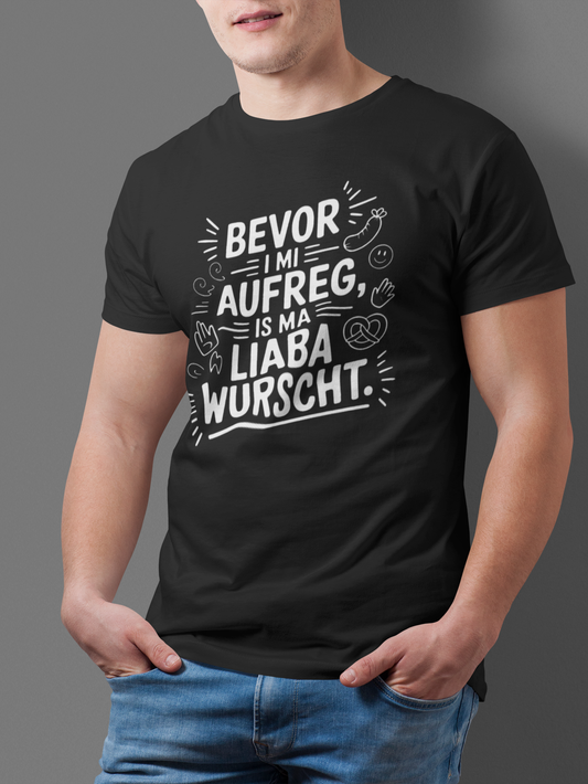 Junger Mann trägt schwarzes T-Shirt mit weißem Text „Bevor I mi aufreg, is ma liaba wurscht“, Oberkörperansicht