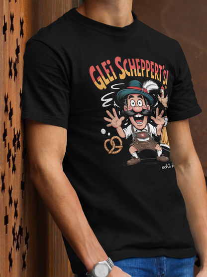 Junger Mann trägt schwarzes T-Shirt mit Fun-Motiv „Glei scheppert’s“, Oberkörperansicht