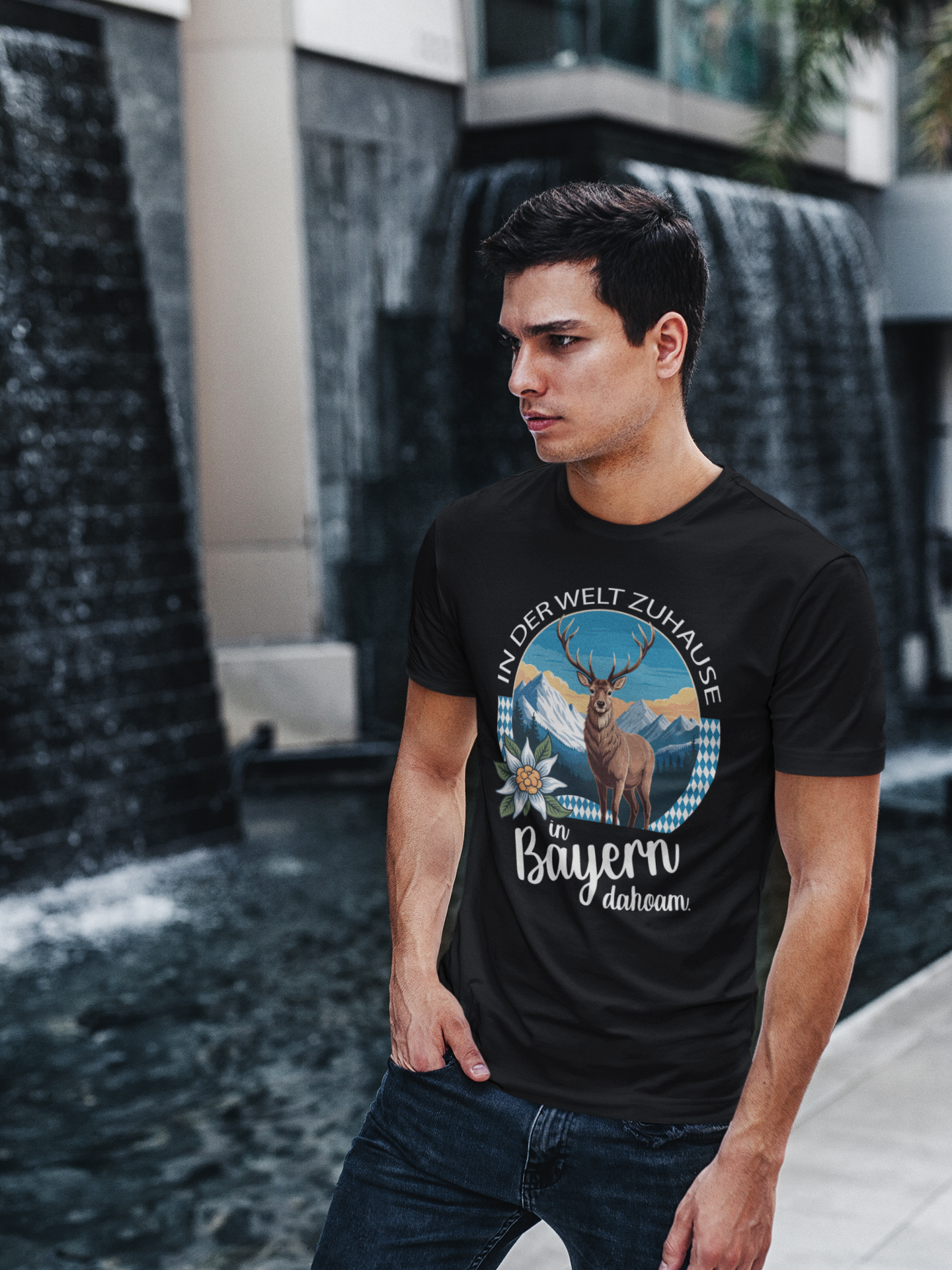 Junger Mann trägt schwarzes T-Shirt mit Heimatmotiv und Spruch „In Bayern dahoam“, Oberkörperansicht