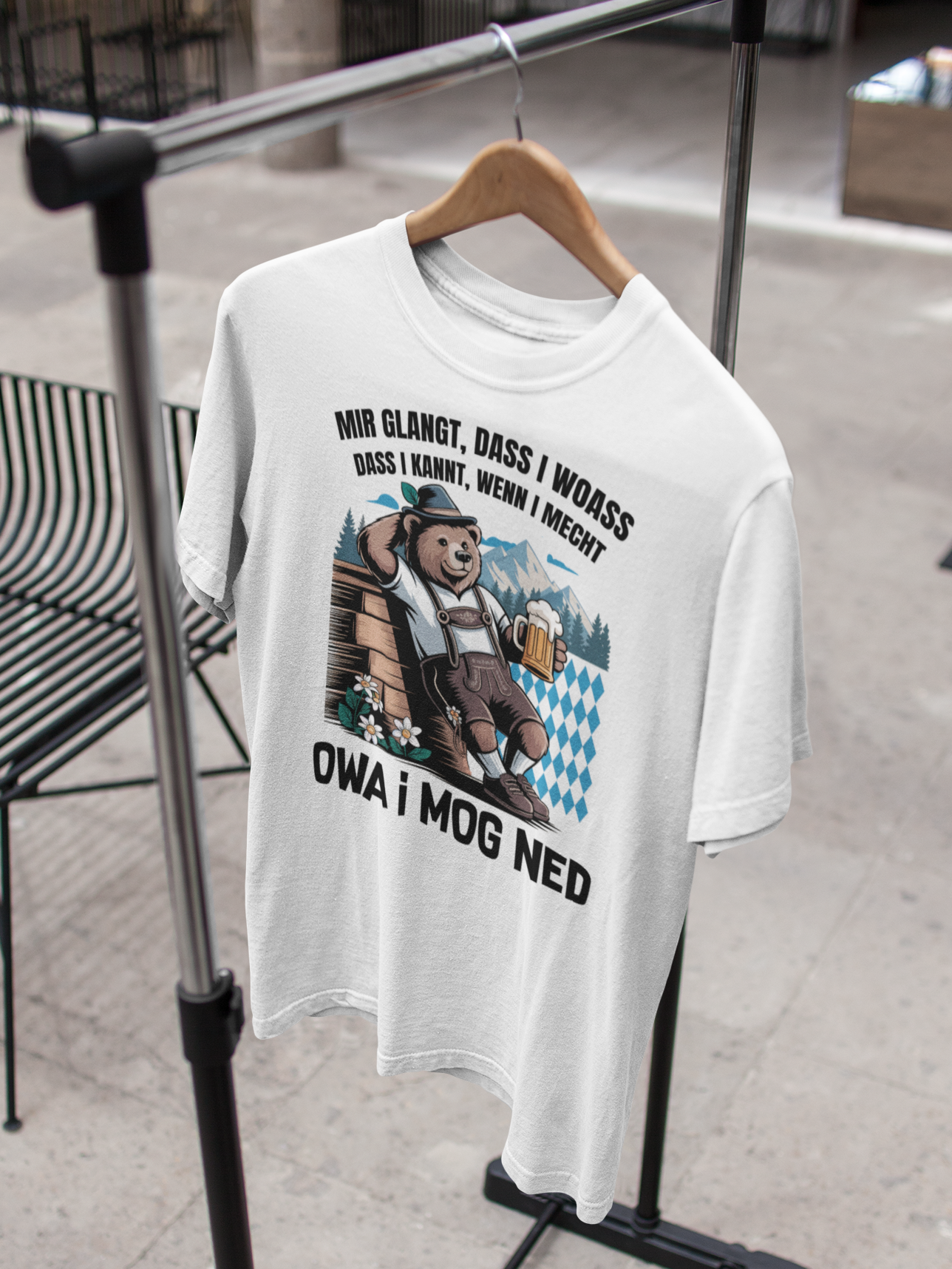Weißes T-Shirt mit bayerischem Bär und Spruchmotiv auf Kleiderbügel an Kleiderständer