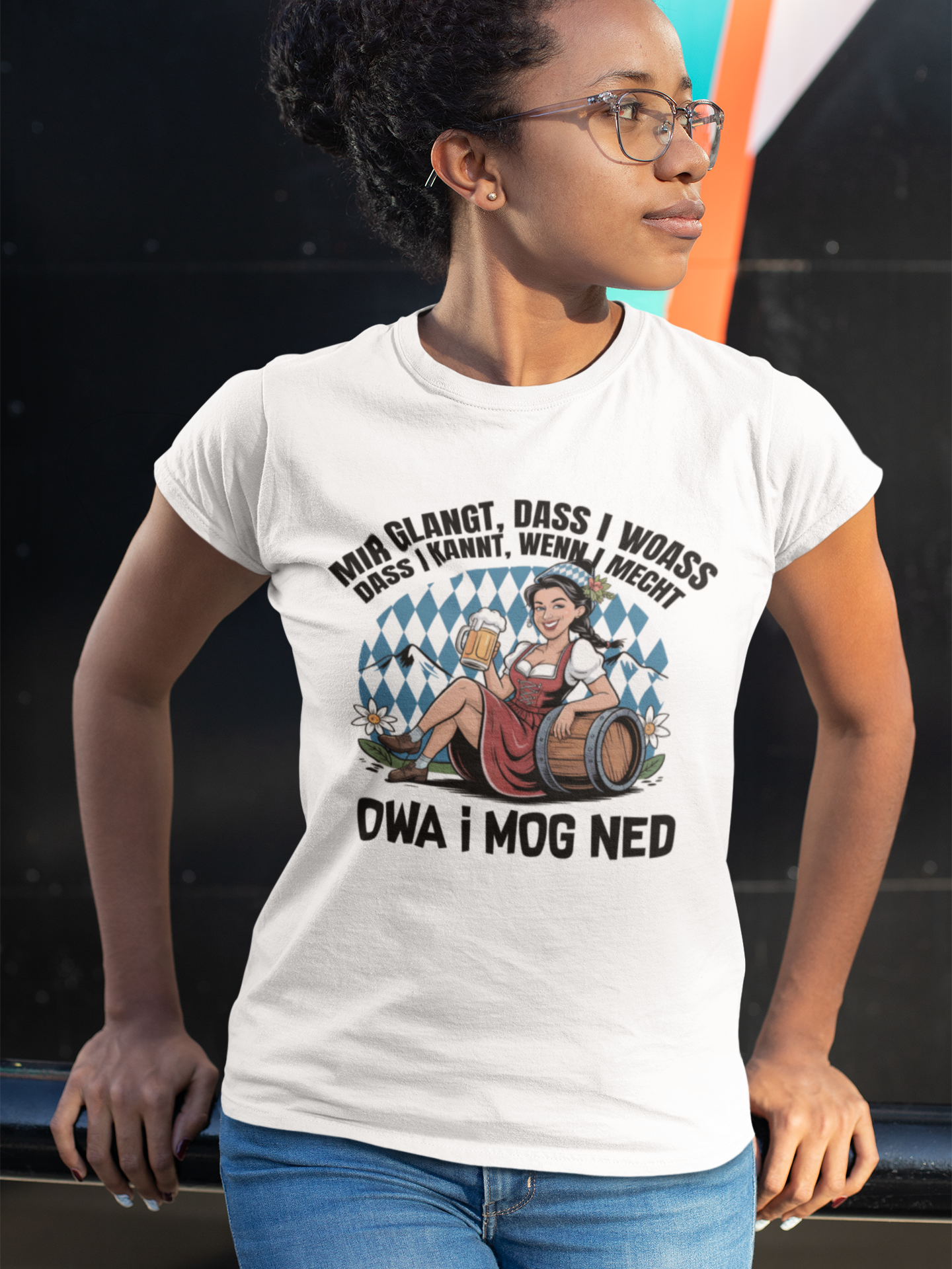 Junge Frau trägt weißes T-Shirt mit Motiv „Owa i mog ned“ und bayrischem Madl, Oberkörperansicht