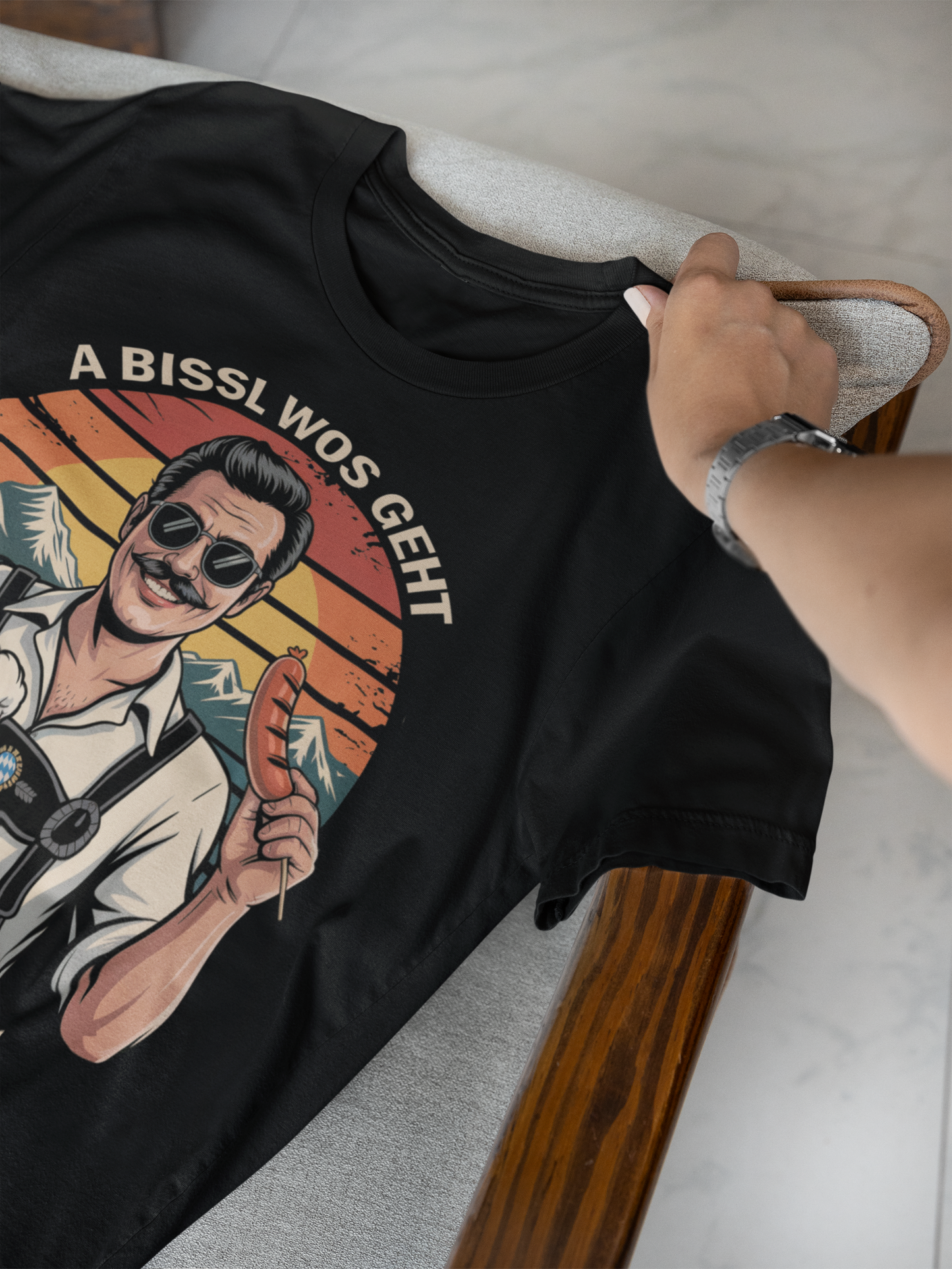 Schwarzes T-Shirt mit Retro-Bayer und Spruch „A bissl wos geht oiwei nu“, liegend