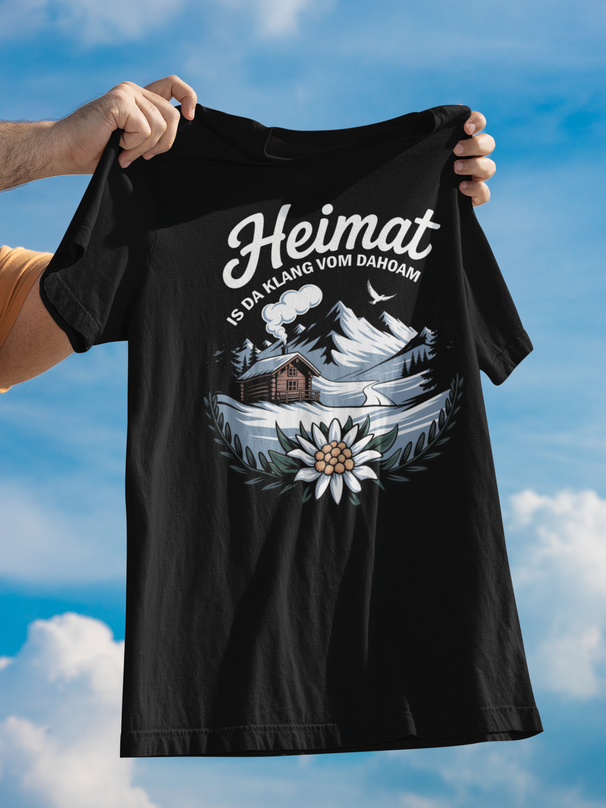 Hände halten Shirt in die Luft, mit barischem Motiv und Aufdruck "Heimat"