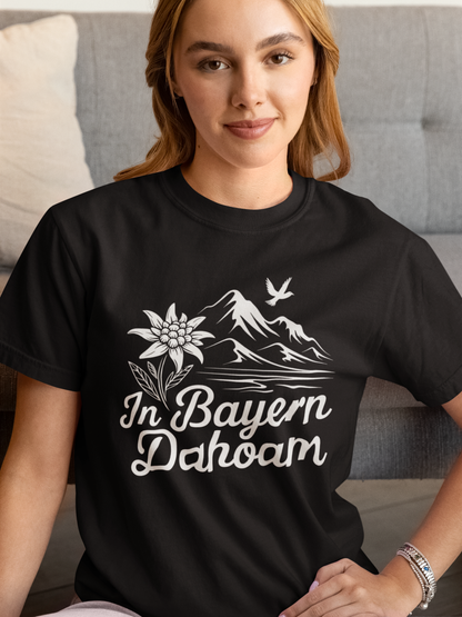 Junge Frau trägt schwarzes T-Shirt mit Bergpanorama und „In Bayern dahoam“-Schriftzug, Oberkörperansicht