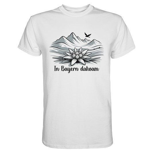 Weißes T-Shirt mit schwarzem Druck: stilisiertes Bergpanorama, Edelweiß und Text „In Bayern Dahoam“